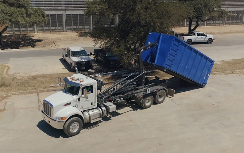 dumpster rental truck lifting a dumpster